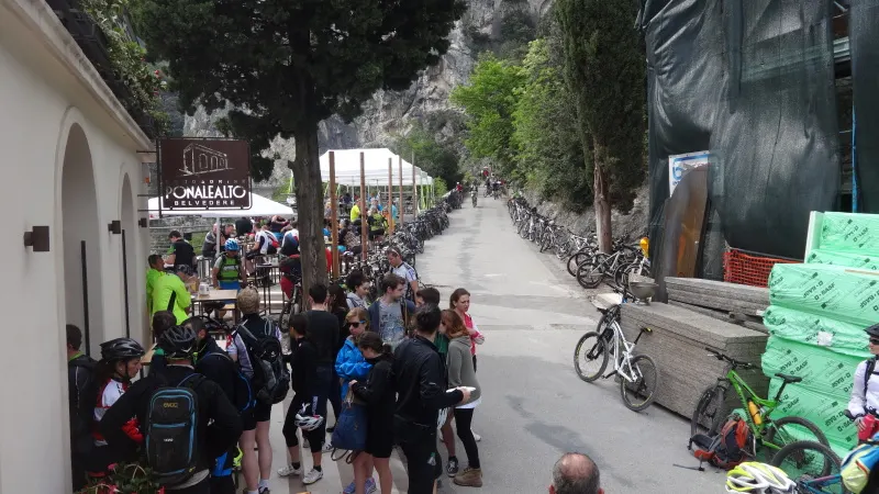 Ciclisti in sosta lungo una strada di montagna tra le case