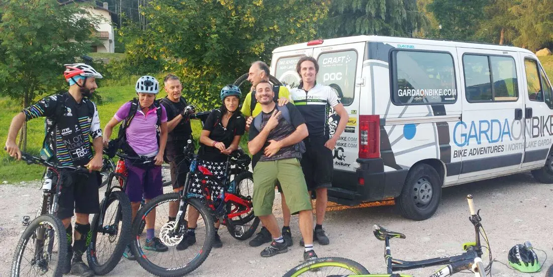 Biker e guide GardaOnBike davanti a un furgone